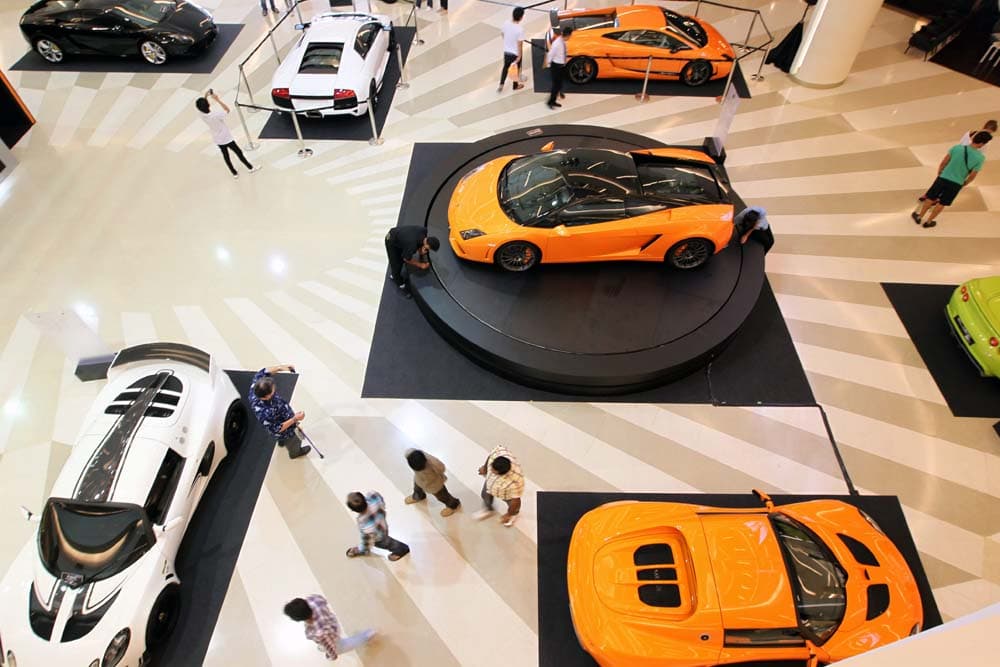 زوار أحد مراكز التسوق في تايلاند يلقون نظرة على احدث السيارات الرياضية