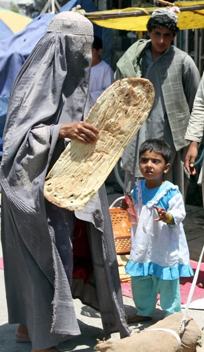 امرأة أفغانية تحمل الخبز لأطفالها في أفغانستان