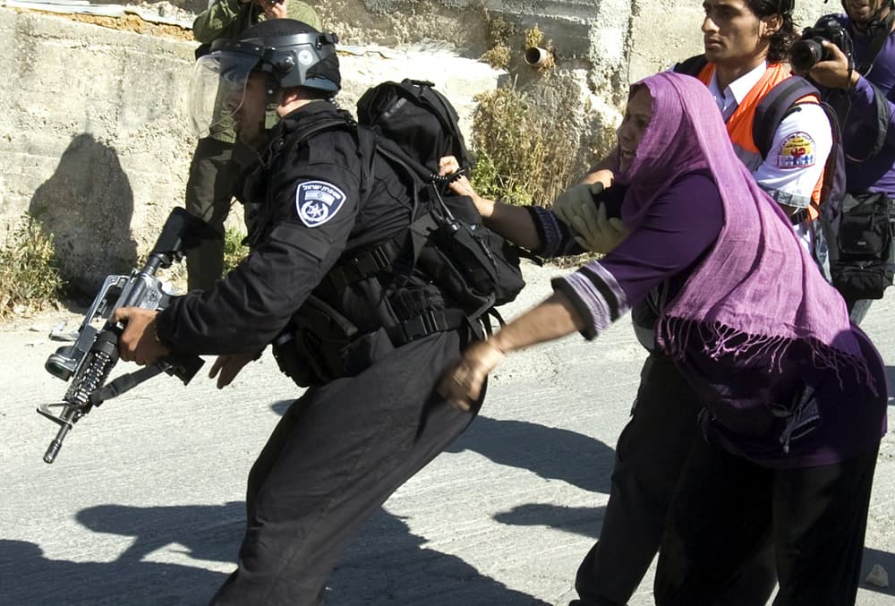 امرأة فلسطينية تحاول منع رجال شرطة مكافحة الشغب الاسرائيلية من اعتقال ابنها   في حي القدس