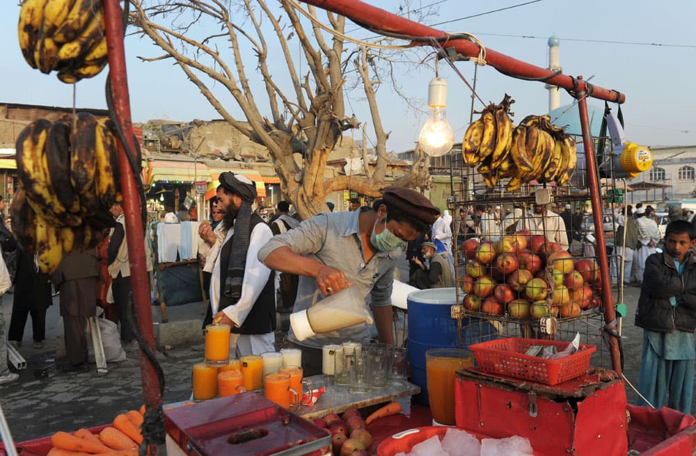 بائع أفغاني يصب في أكواب العصير الطازج في مدينة كابول