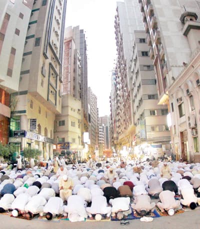 مصلون يؤدون الصلاة أمس في أحد الشوارع بجوار الحرم المكي الشريف