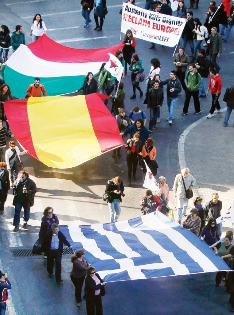 متظاهرون يحملون أعلام اليونان وإسبانيا وإيطاليا، وهي الدول المتضررة من خطط التقشف، خلال مسيرة احتجاجية في أثينا عاصمة اليونان أم
