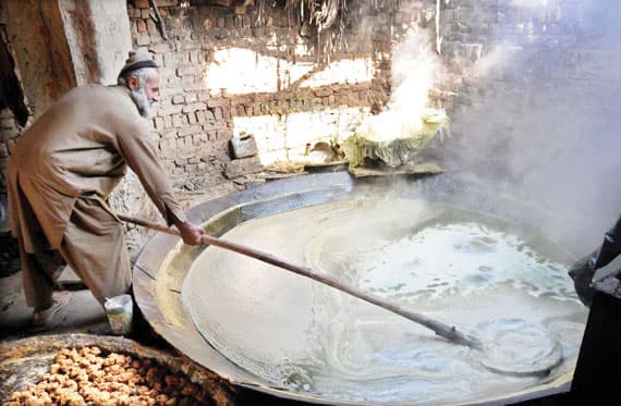 ناس وناس: باكستاني يعد السكر البني من عصير قصب السكر في بيشاور. وتعد صناعة السكر في باكستان أكبر الصناعات الزراعية في البلاد