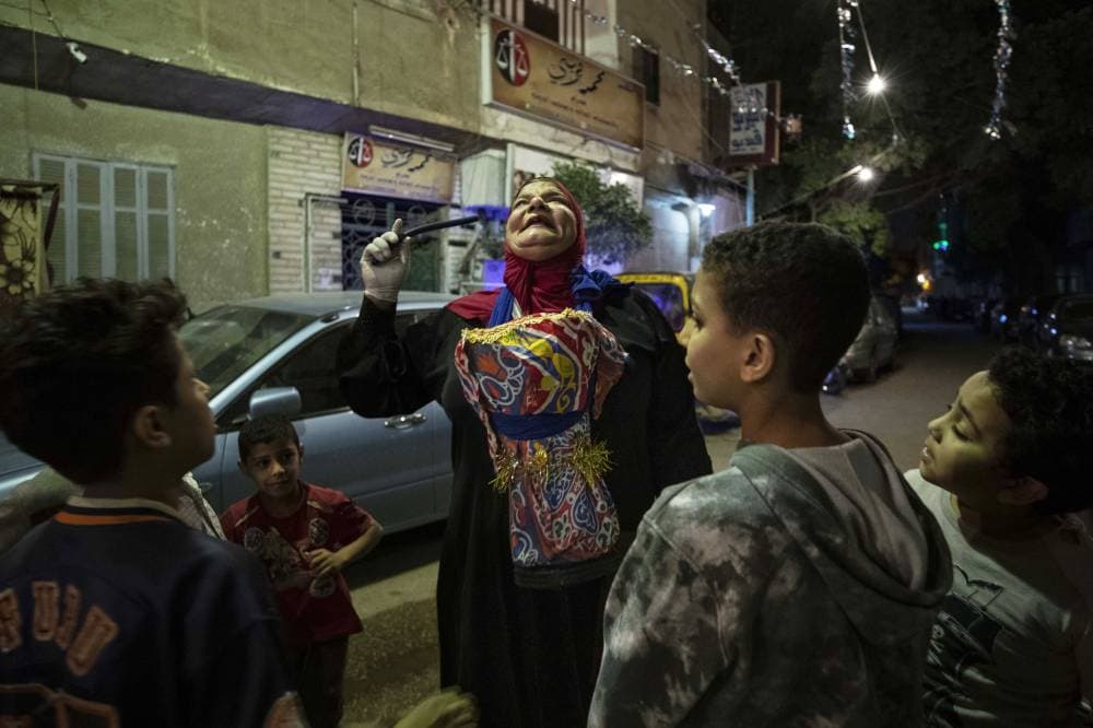 مسحراتية تدعى الحاجة دلال توقظ المواطنين لتناول السحور في أحد شوارع القاهرة."أ.ب"