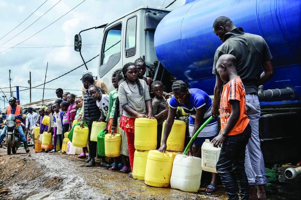 سكان حي كيبيرا الفقير في العاصمة الكينية نيروبي يصطفون لتعبئة مياه مجانية توزعها الحكومة لضمان وصول مياه نظيفة من أجل الحد من انتشار فيروس كورونا.      «الفرنسية»