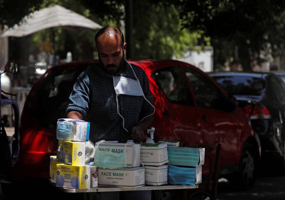 بائع متجول يبيع كمامات لمنع انتشار "كوفيد - 19" وسط مدينة القاهرة. "رويترز"