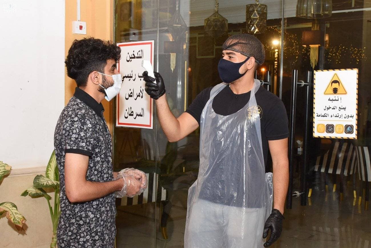 تطبيق الإجراءات الاحترازية على مدخل مقهى. «واس »
