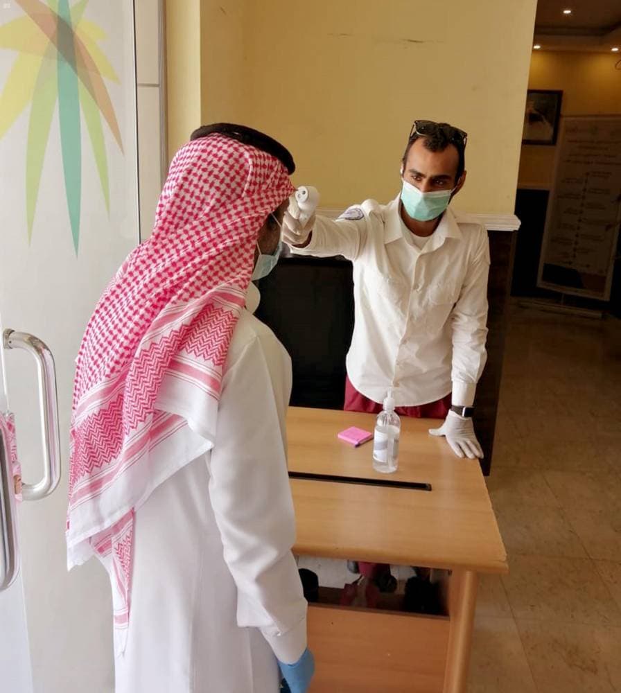 قياس درجة مراجع في مدخل إحدى الدوائر الحكومية. "واس"