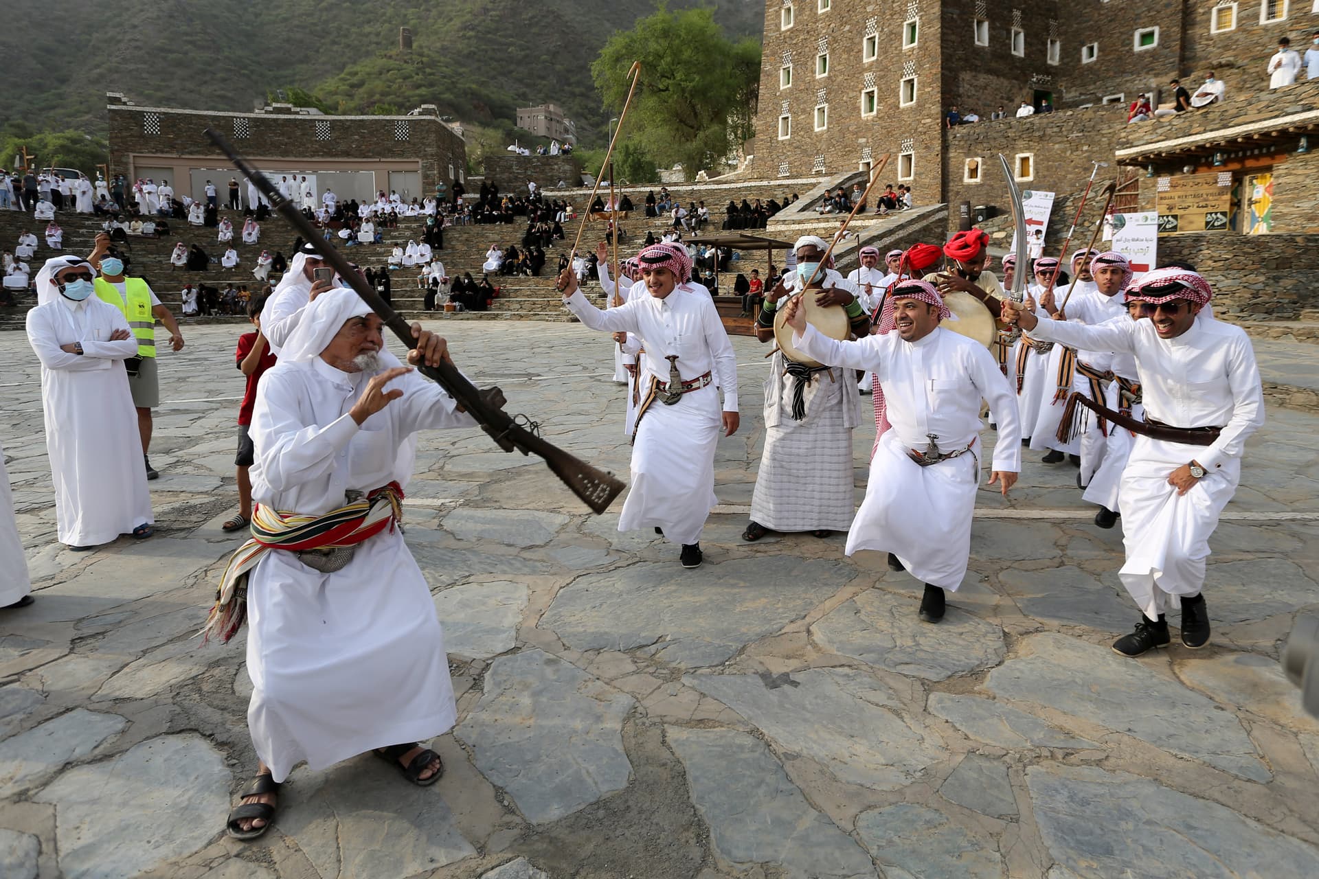 أهالي رجال ألمع يستقبلون زوار صيف السعودية بالعرضة