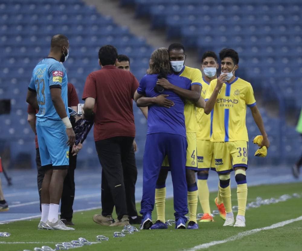 كارينيو يعانق لاعبي النصر أمس.