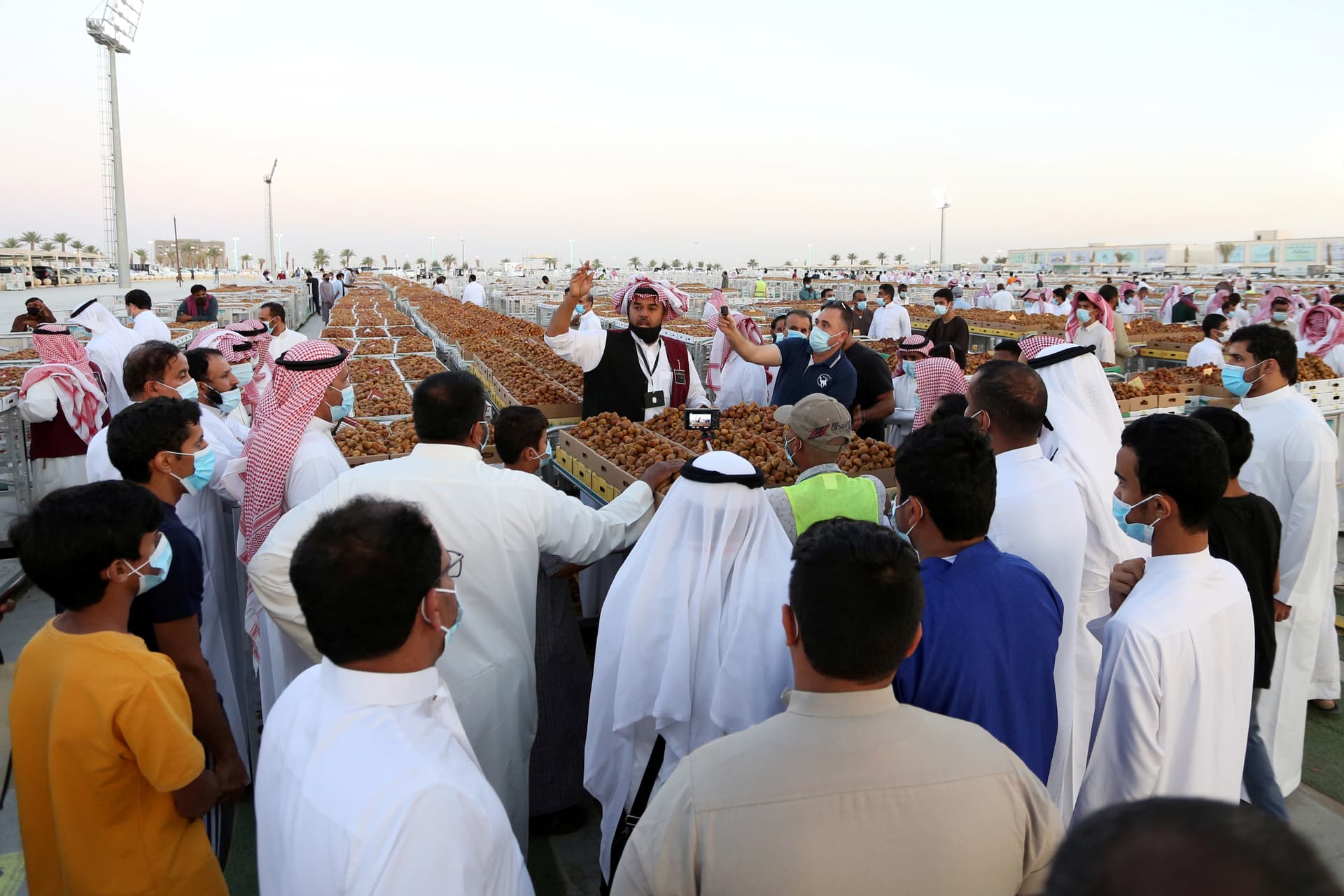 باعة تمور يعرضون منتجات مزارع القصيم في موسم عنيزة للتمور