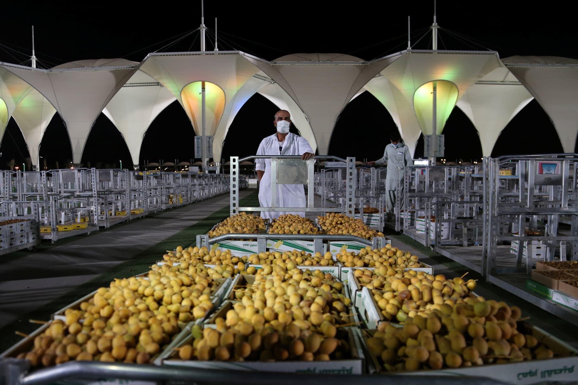 باعة تمور يعرضون منتجات مزارع القصيم في موسم عنيزة للتمور