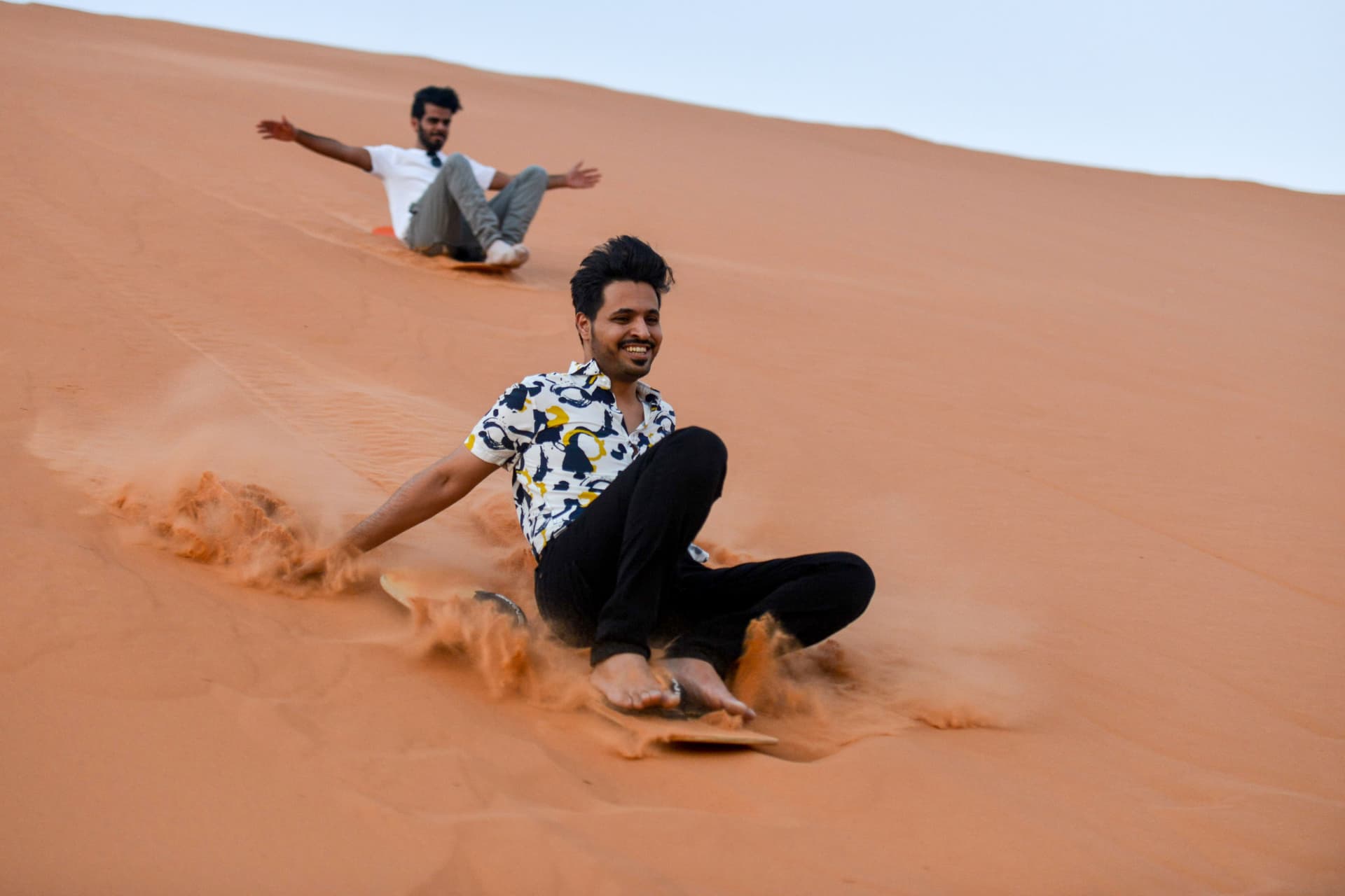 شبان يمارسون هواية التزلج على الرمال في الرياض  