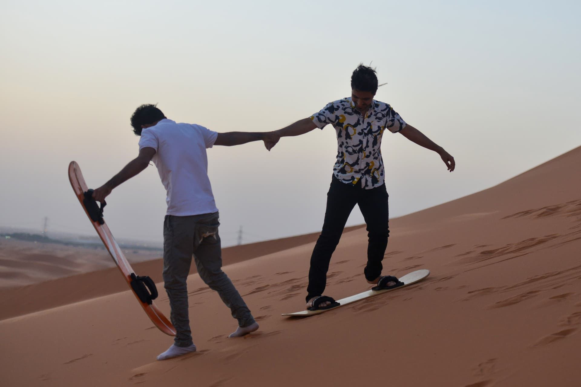 شبان يمارسون هواية التزلج على الرمال في الرياض  