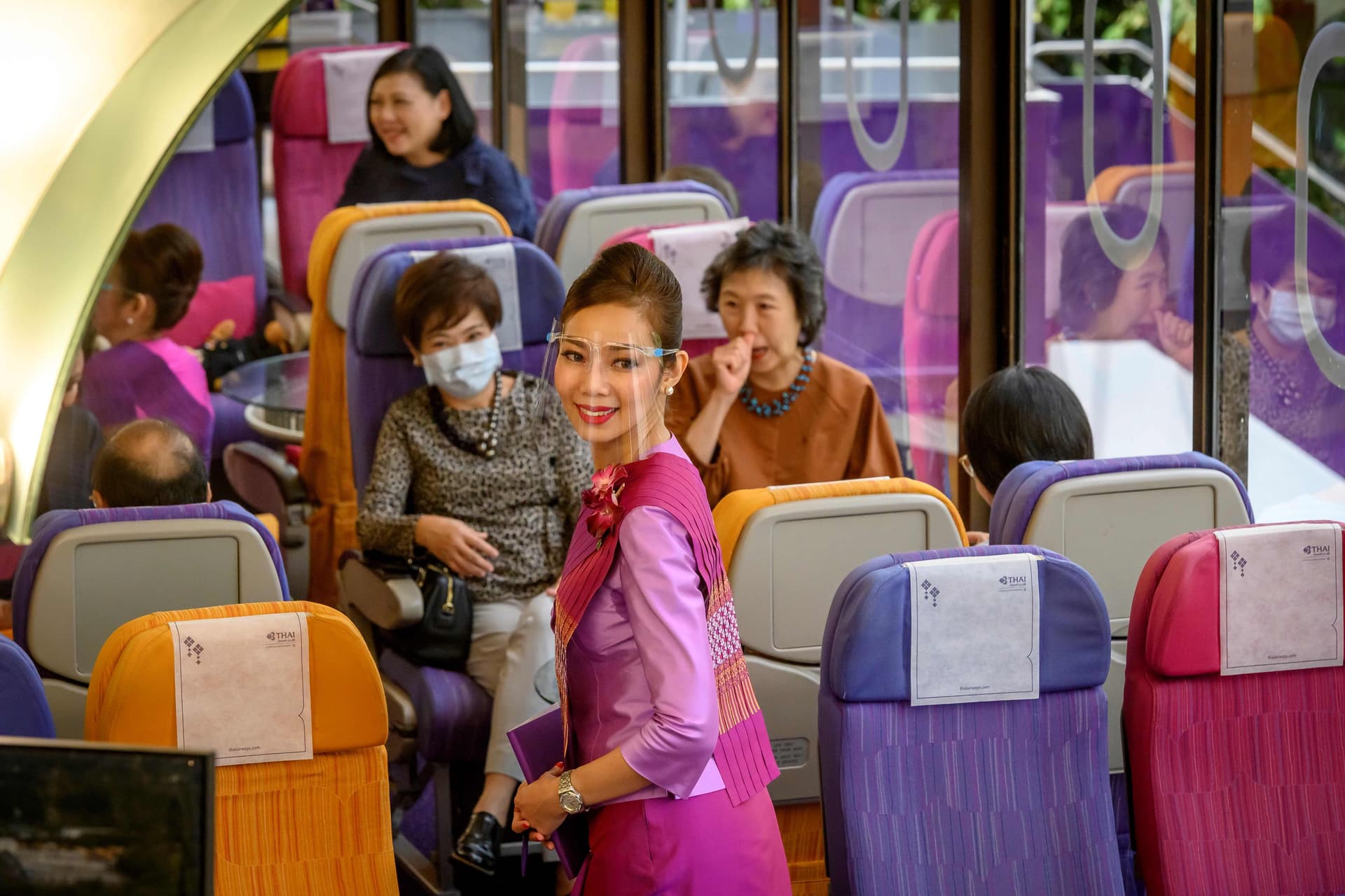  مضيفة طيران تابعة للخطوط التايلاندية تقدم الوجبات في مطعم على طراز طائرة في مقر الشركة  