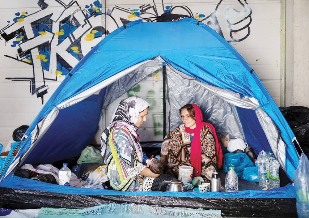 عائلة مهاجرة داخل مخيم مؤقت للاجئين في جزيرة ليسبوس اليونانية