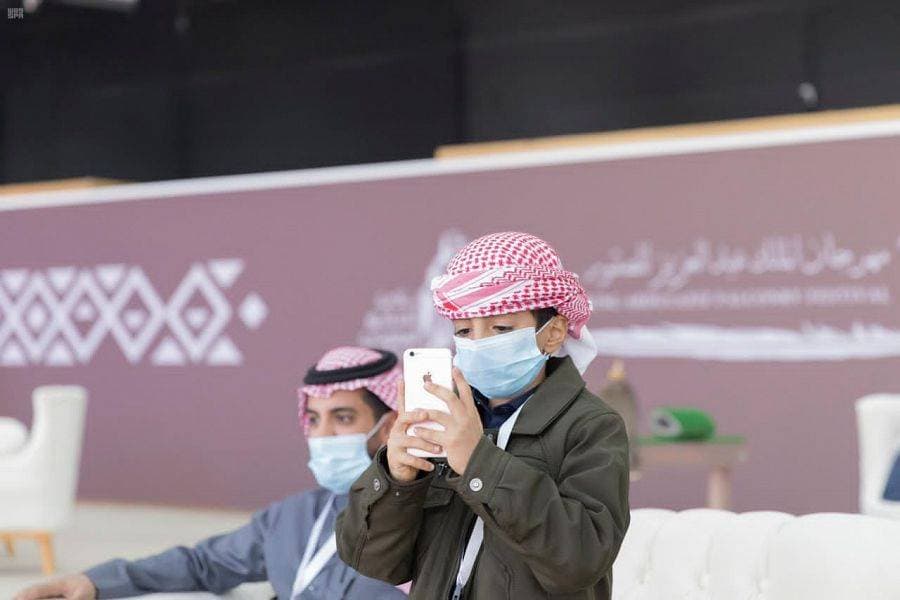 طفل يوثق فعاليات المهرجان عبر هاتفه.واس"