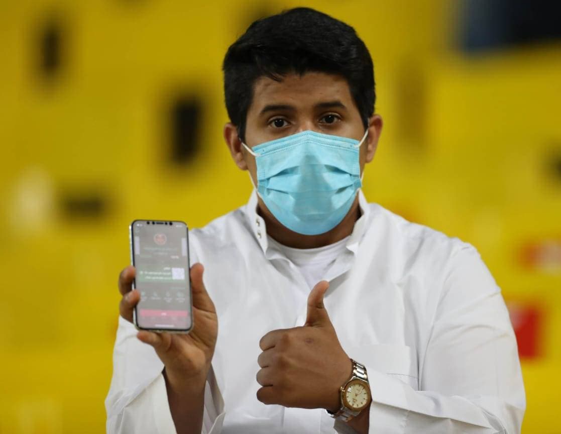 مشجع يرفع جواله الذي يوضح تحصينه بلقاح عن فيروس كورونا من خلال تطبيق "توكلنا"، بعد أن سمحت وزارة الرياضة بعودة الجماهير للمدرجات في مباراة الأخضر وفلسطين أمس. تصوير: سعد العنزي ـ «الاقتصادية»