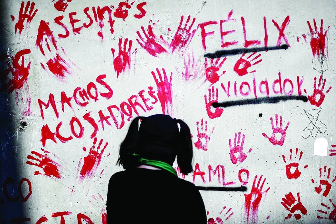 امرأة تنظر إلى لوحة جدارية تحمل أسماء ضحايا العنف ضد المرأة في المكسيك، وذلك في خارج مكتب التحقيق في مكسيكو سيتي. "الفرنسية"