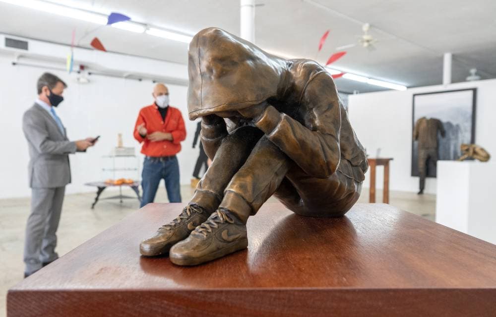 رجلان ينظران إلى عمل فني للفنان دومينيك إسبوزيتو في معرض "بلانك سليت" في ويست بالم بيتش الأمريكية، حيث يتناول المعرض موضوع معاناة ووصمة العار للمرضى النفسيين. "إ ب أ"