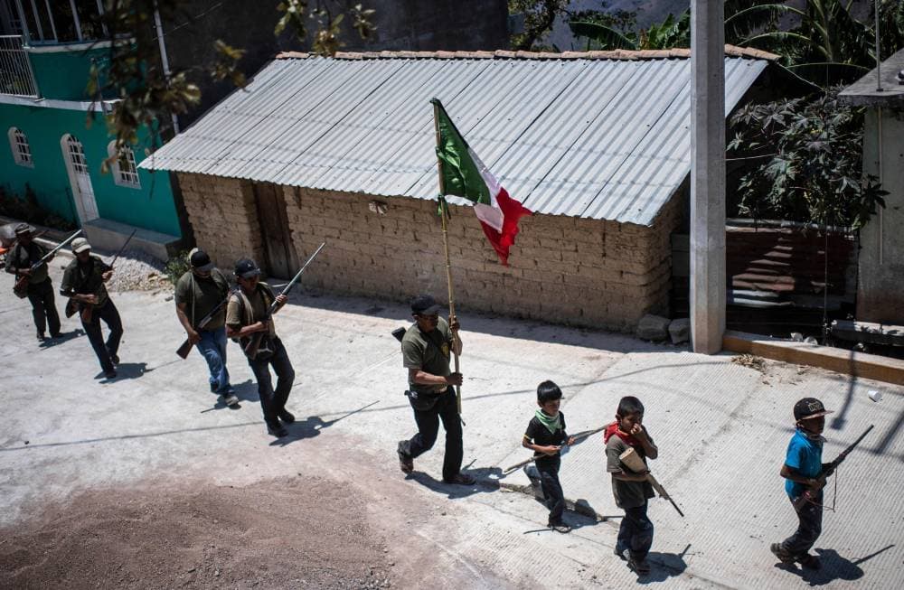 أطفال يسيرون في أحد الشوارع أثناء استعدادهم للمشاركة في تدريب يتبع لقوة أهلية، في قرية آياهوالتمبا المكسيكية حتى يتمكنوا من حماية أنفسهم من الجماعات الإجرامية. "الفرنسية"