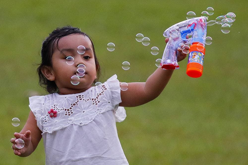طفلة تلعب بالفقاعات قبيل الإفطار في إحدى حدائق  كوالالمبور."إ.ب.أ"