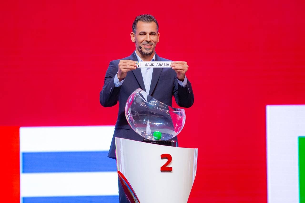 يونس يسحب ورقة المنتخب السعودي خلال مراسم القرعة.