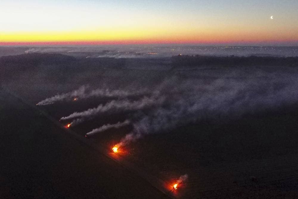 صورة جوية لدخان متصاعد جراء إشعال نيران بالقرب من حقول لحمايتها من الصقيع وذلك في بلدة فوفراي في فرنسا. "الفرنسية"