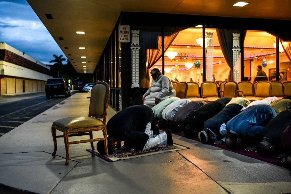 مسلمون يؤدون صلاة المغرب خارج أحد مطاعم فلوريدا. «الفرنسية »