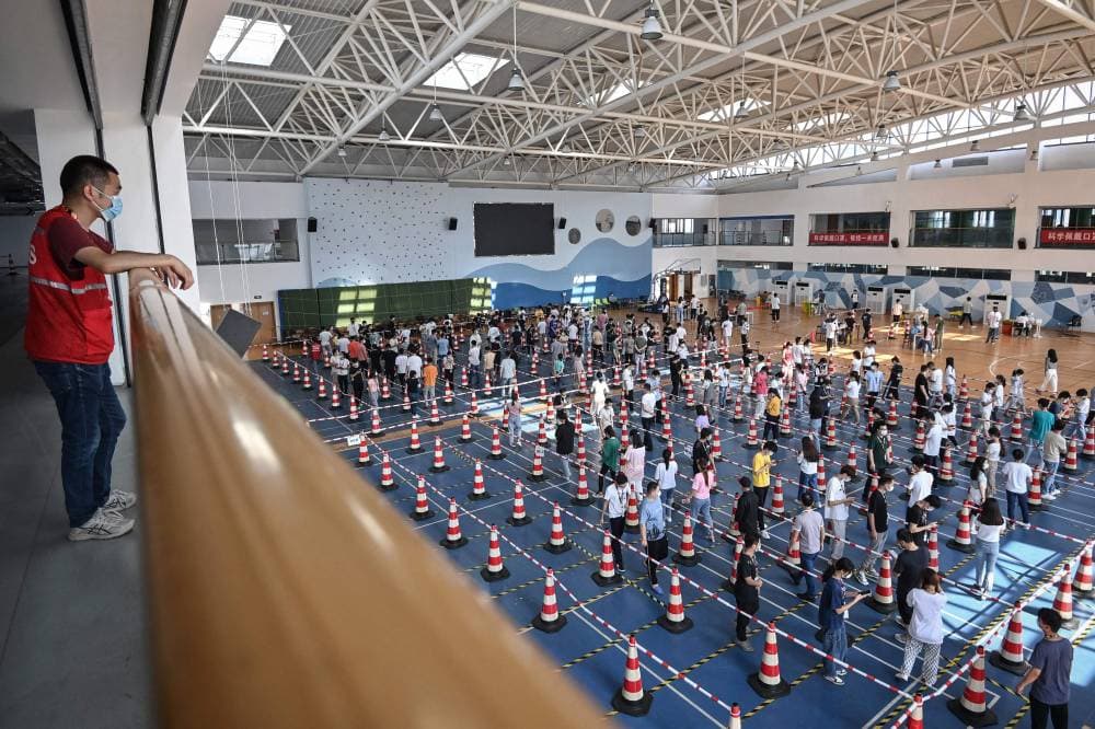 صينيون يصطفون للخضوع لفحص كورونا في مدينة ووهان الصينية. "الفرنسية"