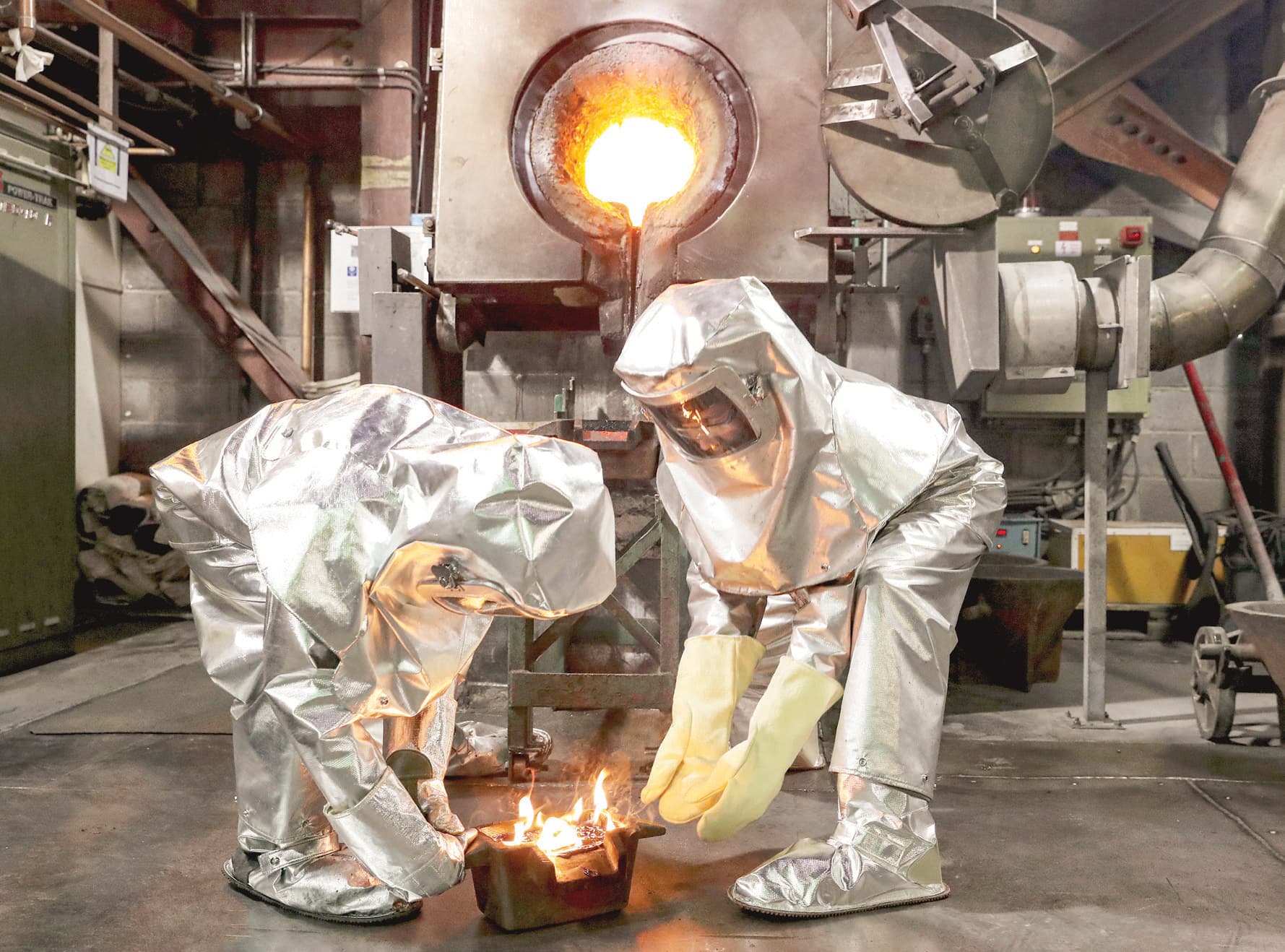 عمال يحملون قضبانا جديدة من الذهب المصهور في مصنع في منجم كومتر في قرغيزستان