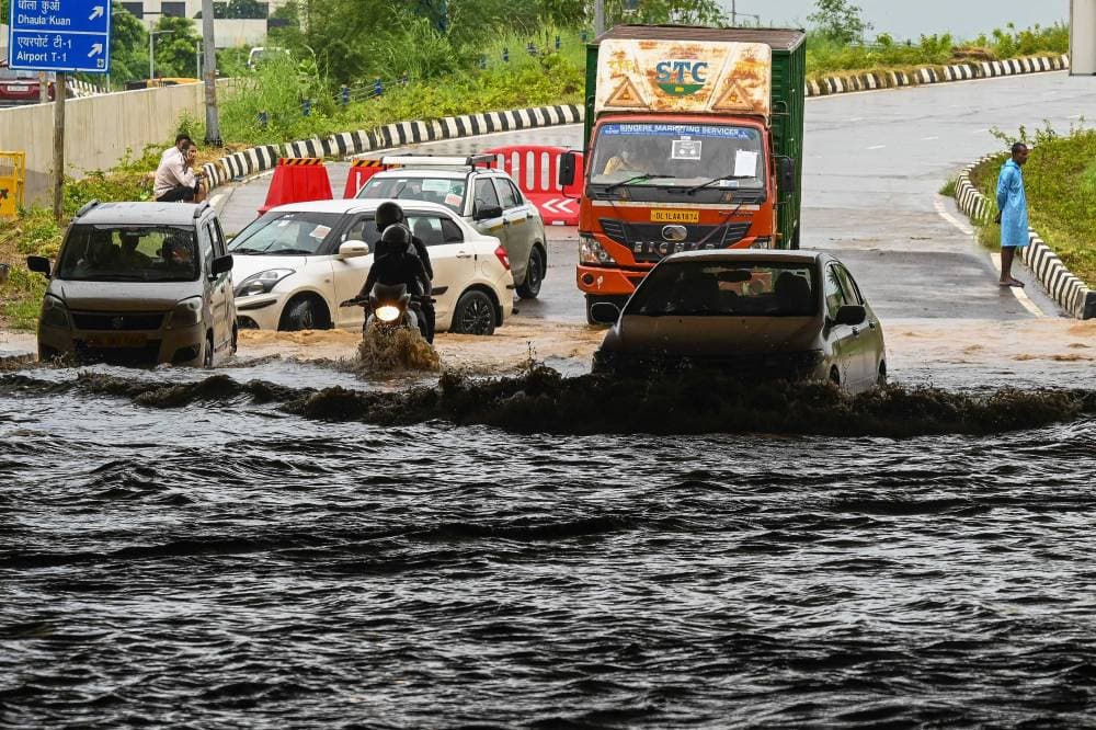سائقو السيارات يشقون طريقهم على طول نفق تغمره المياه أثناء هطول أمطار غزيرة في مدينة نيودلهي الهندية. "الفرنسية"
