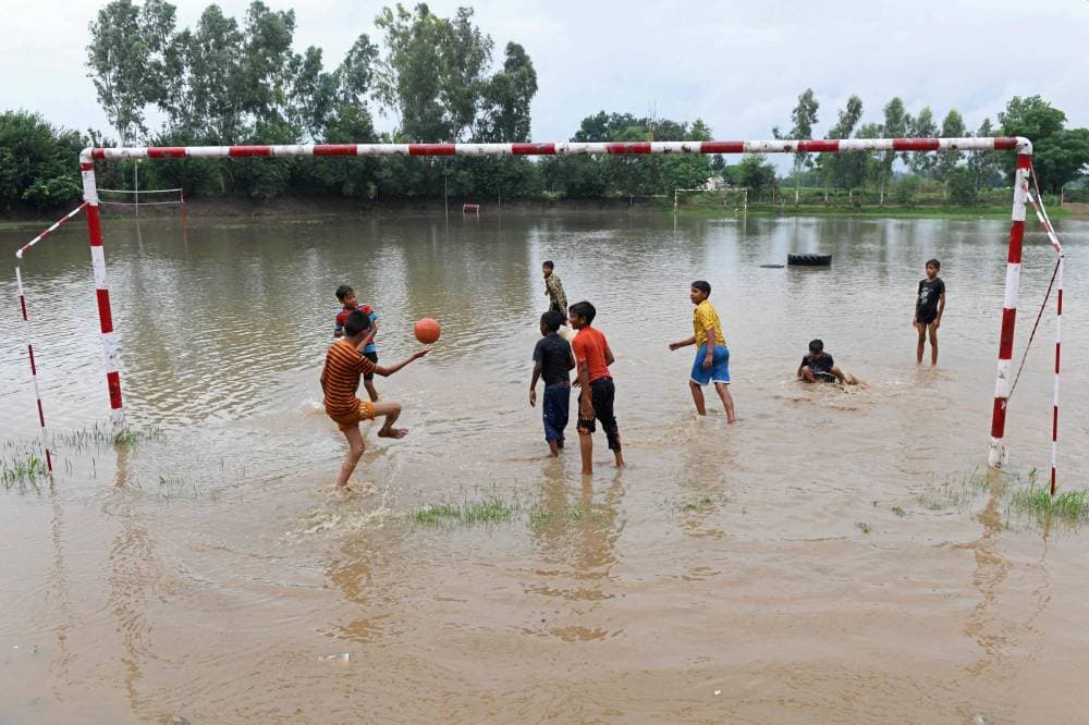 أطفال يلعبون كرة القدم في ملعب غمرته المياه، نتيجة الأمطار الغزيرة، على مشارف أمريتسار الهندية."الفرنسية"