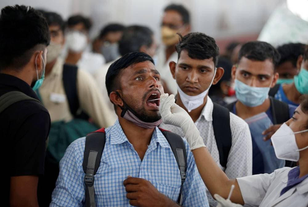 A healthcare worker collects swab from a man for a RT-PCR test after he arrived at a railway station during the ongoing coronavirus disease (COVID-19) outbreak,  in Ahmedabad, India, September 2, 2021. REUTERS/Amit Dave