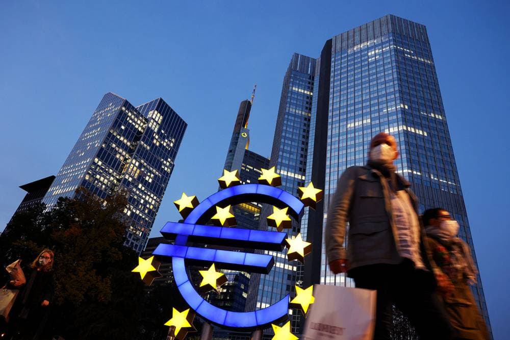 People wearing face masks walk in front of a euro sign and the former ECB headquarter in the city center of Frankfurt am Main, western Germany, on October 21, 2020. (Photo by Yann Schreiber / AFP) (Photo by YANN SCHREIBER/AFP via Getty Images)