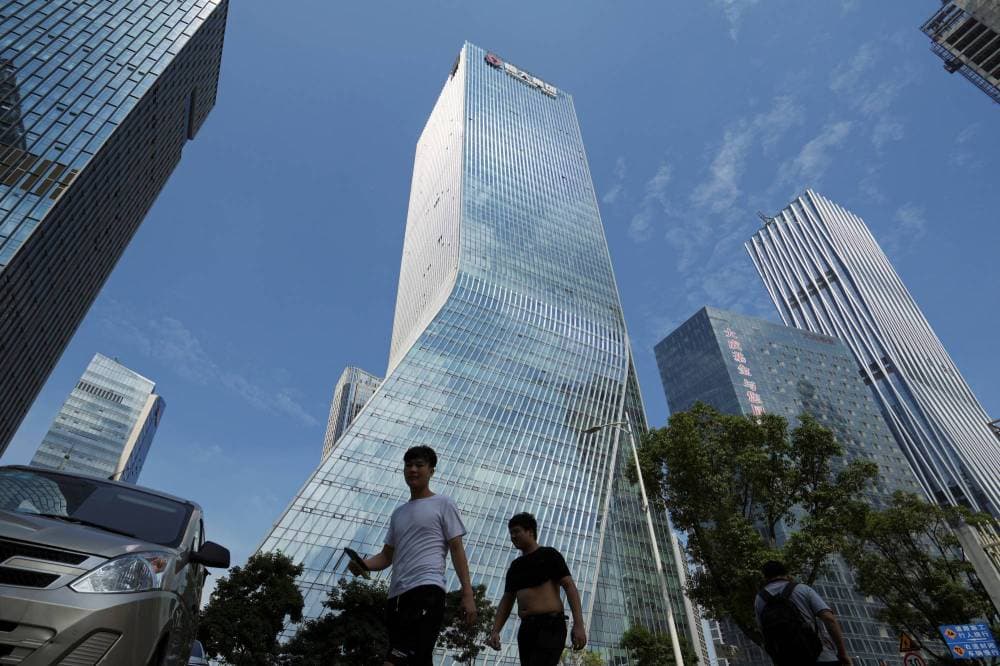 مارة يعبرون من أمام المقر الرئيسي لشركة إيفرجراند في مدينة شينزن في أيلول (سبتمبر) 2021. تصوير: آلي سونج "رويترز"