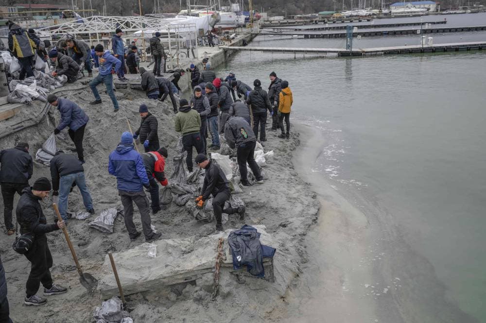 أوكرانيون يملأون الأكياس بالرمال على طول شاطئ مدينة أوديسا أمس. "الفرنسية"