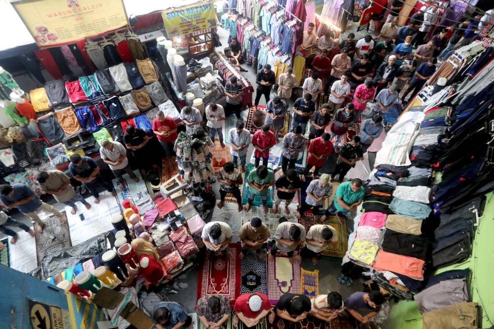 إندونيسيون يؤدون صلاة الجمعة داخل سوق تاناهابانج في جاكرتا.  "إ.ب.أ