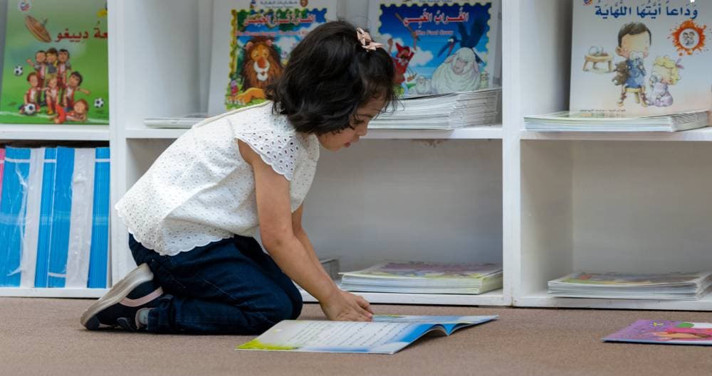 طفلة تقرأ كتابا.
