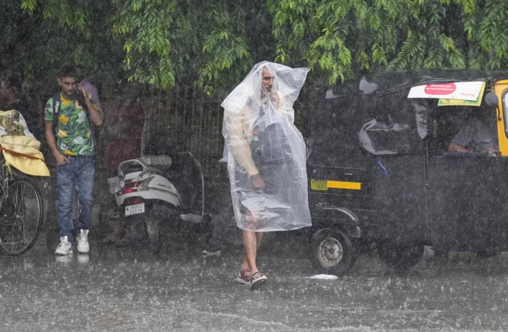 هندي يرتدي كيسا من البلاستيك للوقاية من الأمطار، التي تهطل بكثافة على جامو."أ. ب"