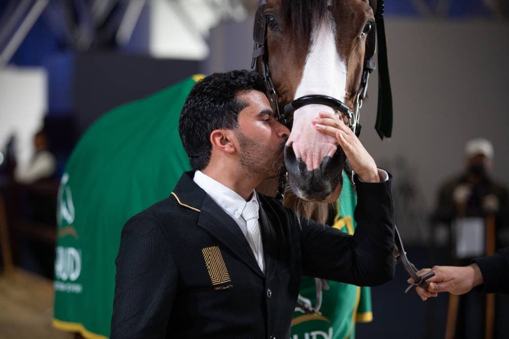 الحربي يقبل حصانه بعد الفوز بالشوط السادس.