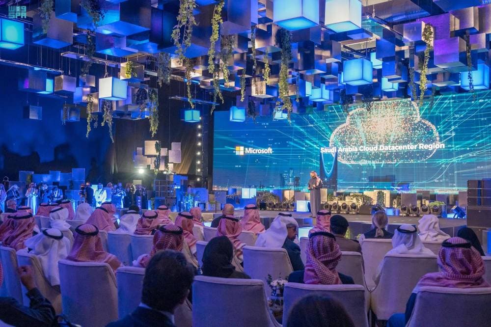 فلسطيني يسير بأكياس حلوى أمام أنقاض مبنى دمرته الغارات الإسرائيلية