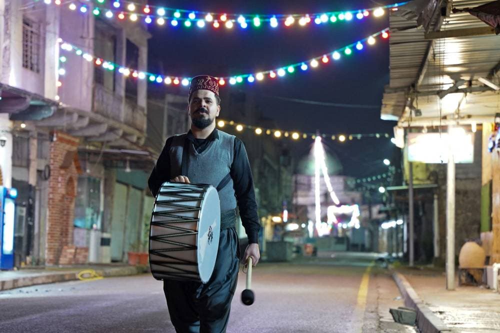 مسحراتي يوقظ المسلمين لتناول السحور في الموصل العراقية."الفرنسية"