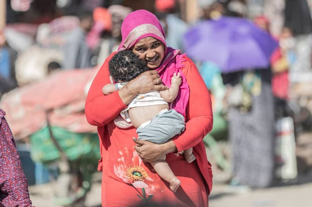 لاجئة من السودان تحمل طفلها الرضيع عبرت الحدود إلى إثيوبيا. "الفرنسية"