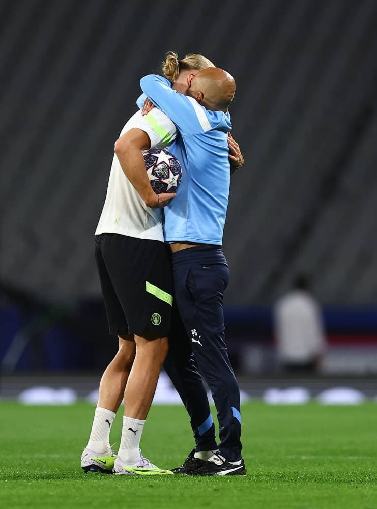 جوارديولا يحتضن هالاند خلال المران. إ.ب.أ