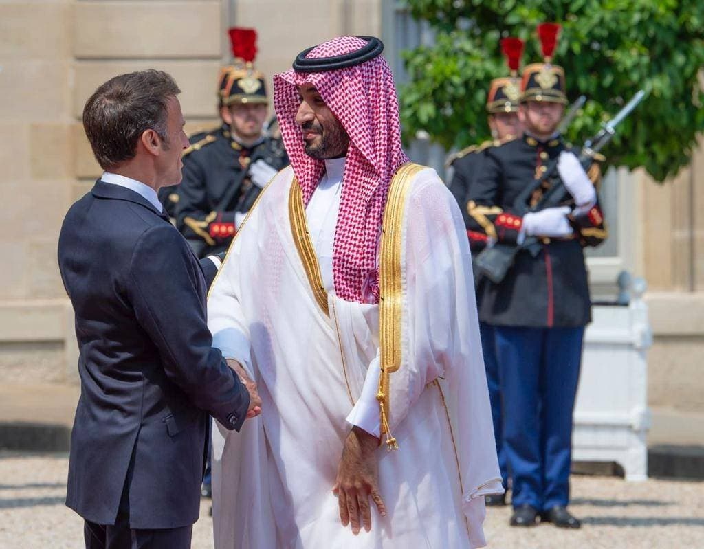 الأمير محمد بن سلمان مصافحا الرئيس إيمانويل ماكرون خلال الاستقبال.