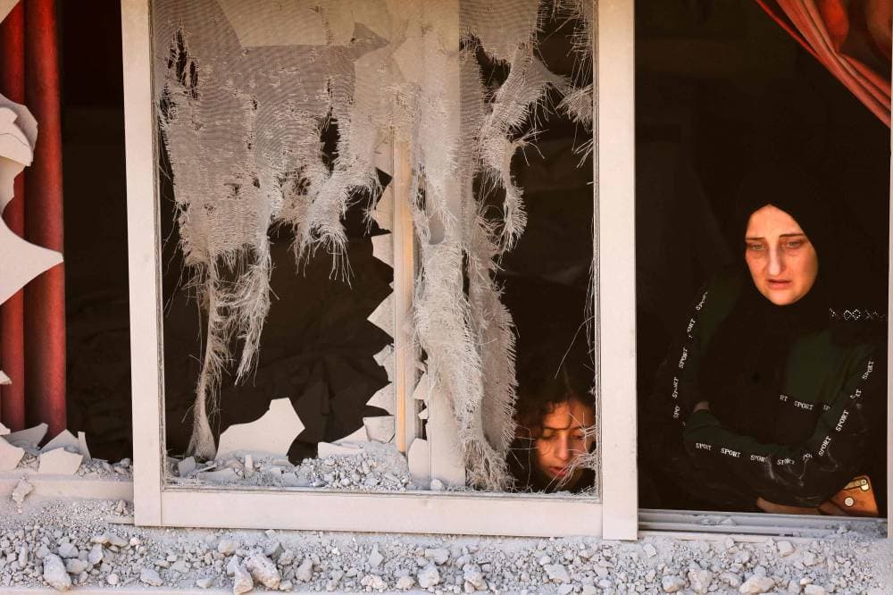 فلسطينية تنظر من نافذة منزلها المدمر في نابلس."الفرنسية"