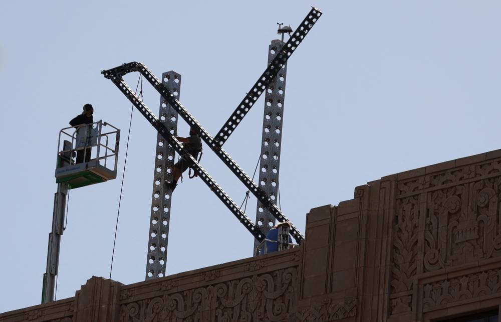 لحظة تفكيك الشعار من على مبنى الشركة."الفرنسية"