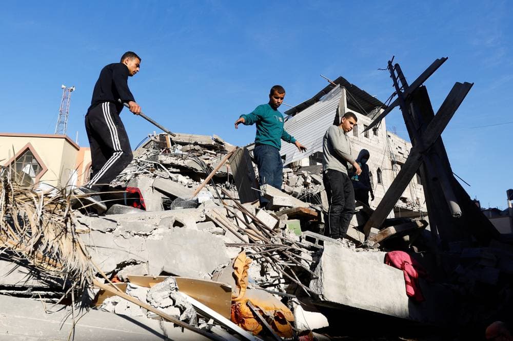 فلسطينيون يقفون على أنقاض منزلهم المدمر في خان يونس."رويترز"