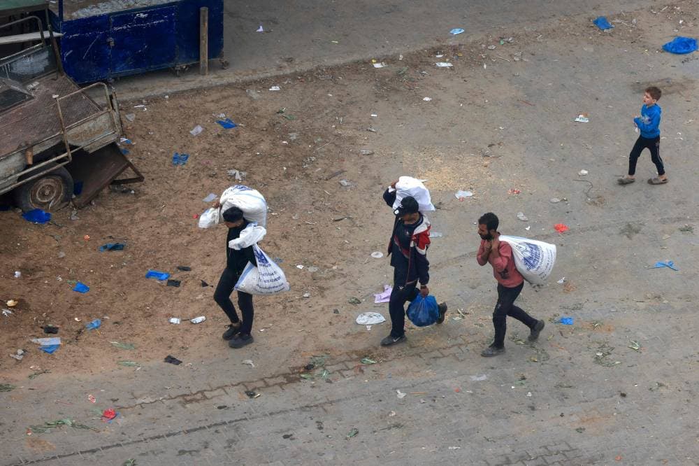 فلسطينيون يحملون أكياسا من المواد الغذائية في رفح جنوب القطاع."الفرنسية"